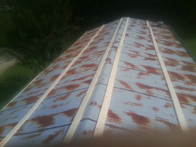 Rusted metal roof panels with new wood purlins before replacement — Storm Damage Roof Repair in D Lo by Roofing Brothers