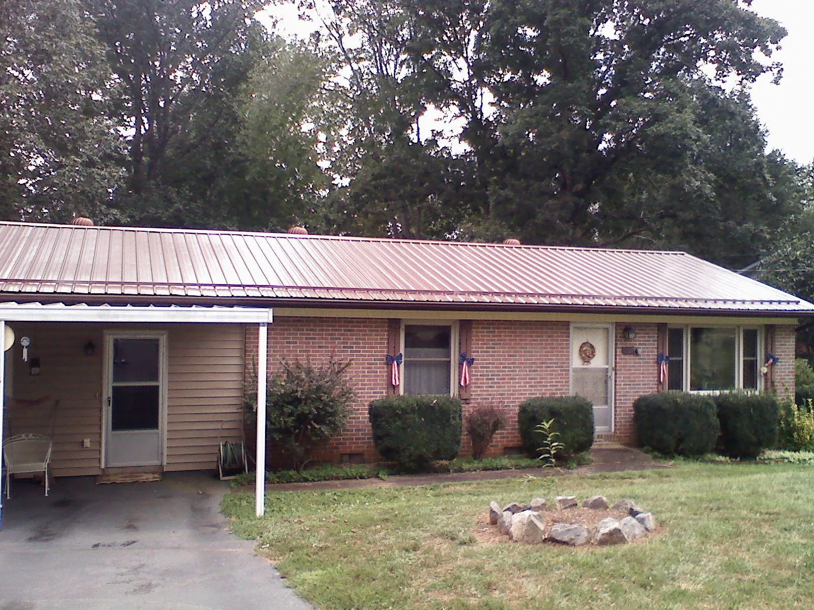 Bronze metal roof and carport on a brick ranch home — Roof Repair work by our crew in D Lo